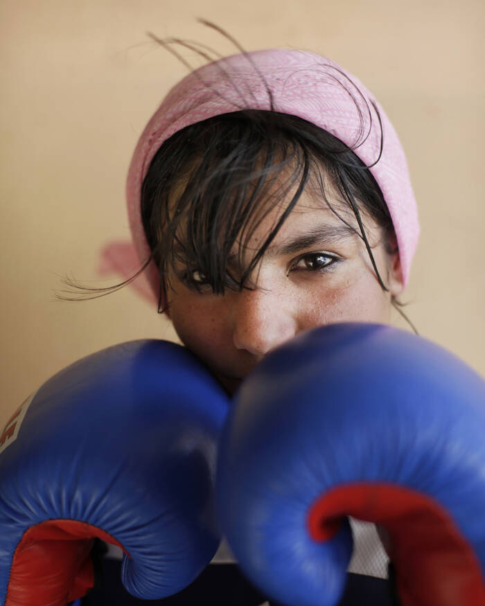 Abbie Trayler-Smith  Sadaf Haruzel, 17, a member of the Girls's Boxing TEam in Kabul, photographed at The National Stadium.
Olympic Dreams: Fighting for Peace
Boxing is making a comeback in Afghanistan after it was banned by the Taliban Regime.  For the first time in the history of Afghanistan the country also now has an Afghan Amateur Women’s Boxing Association, financed and established by CPAU under the auspices of The Afghan Olympic Federation.
Afghanistan’s first female boxing team has fought hard to be accepted in Afghan society.  A group of teenage girls, aged 14 to 20, train 3 times a week at the dingy National Stadium in Kabul, once used for Taliban executions.  And now, with Women’s Boxing tipped to become an Olympic sport, the girls are fighting for their chance to travel to the UK as part of Afghanistan’s first female Olympic boxing team for London 2012.
.
Shabnam, 17, is one of three sisters in the team. She has been boxing since she was 11 and has already taken part in an international competition in Vietnam. She says: “I want to win a medal for myself and for my country. Afghanistan has been through a lot during my lifetime. I want to make my country proud. Why shouldn’t girls do it? In Afghanistan now we can do anything”
Saber Sharifi a fit 50-year-old who became Afghanistan’s boxing star in the 1980s by winning a silver medal at the 1982 Asia Games in Delhi, has become a champion of the programme and its coach.
“Afghan women are brave,” he said. “We want our girls to do sports. Some people say it is very dangerous for girls to do boxing. Others say Afghanistan is not ready for this. These girls are proving those people wrong.”