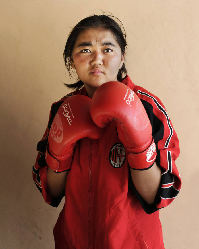 Abbie Trayler-Smith  Olympic Dreams: Fighting for Peace
Boxing is making a comeback in Afghanistan after it was banned by the Taliban Regime.  For the first time in the history of Afghanistan the country also now has an Afghan Amateur Women’s Boxing Association, financed and established by CPAU under the auspices of The Afghan Olympic Federation.
Afghanistan’s first female boxing team has fought hard to be accepted in Afghan society.  A group of teenage girls, aged 14 to 20, train 3 times a week at the dingy National Stadium in Kabul, once used for Taliban executions.  And now, with Women’s Boxing tipped to become an Olympic sport, the girls are fighting for their chance to travel to the UK as part of Afghanistan’s first female Olympic boxing team for London 2012.
.
Shabnam, 17, is one of three sisters in the team. She has been boxing since she was 11 and has already taken part in an international competition in Vietnam. She says: “I want to win a medal for myself and for my country. Afghanistan has been through a lot during my lifetime. I want to make my country proud. Why shouldn’t girls do it? In Afghanistan now we can do anything”
Saber Sharifi a fit 50-year-old who became Afghanistan’s boxing star in the 1980s by winning a silver medal at the 1982 Asia Games in Delhi, has become a champion of the programme and its coach.
“Afghan women are brave,” he said. “We want our girls to do sports. Some people say it is very dangerous for girls to do boxing. Others say Afghanistan is not ready for this. These girls are proving those people wrong.”