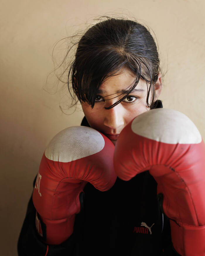 Abbie Trayler-Smith  Olympic Dreams: Fighting for Peace
Samiya Assisiaj, 16, member of the Women's Boxing Team, Kabul.
Boxing is making a comeback in Afghanistan after it was banned by the Taliban Regime.  For the first time in the history of Afghanistan the country also now has an Afghan Amateur Women’s Boxing Association, financed and established by CPAU under the auspices of The Afghan Olympic Federation.Afghanistan’s first female boxing team has fought hard to be accepted in Afghan society.  A group of teenage girls, aged 14 to 20, train 3 times a week at the dingy National Stadium in Kabul, once used for Taliban executions.  And now, with Women’s Boxing tipped to become an Olympic sport, the girls are fighting for their chance to travel to the UK as part of Afghanistan’s first female Olympic boxing team for London 2012.
.
Shabnam, 17, is one of three sisters in the team. She has been boxing since she was 11 and has already taken part in an international competition in Vietnam. She says: “I want to win a medal for myself and for my country. Afghanistan has been through a lot during my lifetime. I want to make my country proud. Why shouldn’t girls do it? In Afghanistan now we can do anything”Saber Sharifi a fit 50-year-old who became Afghanistan’s boxing star in the 1980s by winning a silver medal at the 1982 Asia Games in Delhi, has become a champion of the programme and its coach.
“Afghan women are brave,” he said. “We want our girls to do sports. Some people say it is very dangerous for girls to do boxing. Others say Afghanistan is not ready for this. These girls are proving those people wrong.”