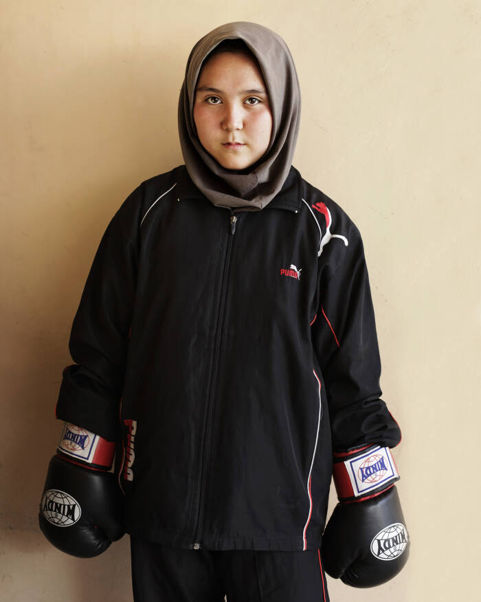 Abbie Trayler-Smith  Olympic Dreams: Fighting for Peace
Masuma Seper, 15. “I’m learning English so I can get a scholarship to America and train to be a doctor. In Afghanistan, it’s difficult for us girls because people don’t want us to leave the house. When we come to training, we have to be home by 5. Otherwise our relatives say that we are bad girls for being outside the home after 5.”
Boxing is making a comeback in Afghanistan after it was banned by the Taliban Regime.  For the first time in the history of Afghanistan the country also now has an Afghan Amateur Women’s Boxing Association, financed and established by CPAU under the auspices of The Afghan Olympic Federation.
Afghanistan’s first female boxing team has fought hard to be accepted in Afghan society.  A group of teenage girls, aged 14 to 20, train 3 times a week at the dingy National Stadium in Kabul, once used for Taliban executions.  And now, with Women’s Boxing tipped to become an Olympic sport, the girls are fighting for their chance to travel to the UK as part of Afghanistan’s first female Olympic boxing team for London 2012.
.
Shabnam, 17, is one of three sisters in the team. She has been boxing since she was 11 and has already taken part in an international competition in Vietnam. She says: “I want to win a medal for myself and for my country. Afghanistan has been through a lot during my lifetime. I want to make my country proud. Why shouldn’t girls do it? In Afghanistan now we can do anything”
Saber Sharifi a fit 50-year-old who became Afghanistan’s boxing star in the 1980s by winning a silver medal at the 1982 Asia Games in Delhi, has become a champion of the programme and its coach.
“Afghan women are brave,” he said. “We want our girls to do sports. Some people say it is very dangerous for girls to do boxing. Others say Afghanistan is not ready for this. These girls are proving those people wrong.”